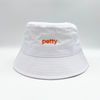 white bucket hat with word petty in peach color 